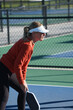 © Tedi S Photography - female pickleball player ready to hit the ball in a pickle ball game on an outdoor court