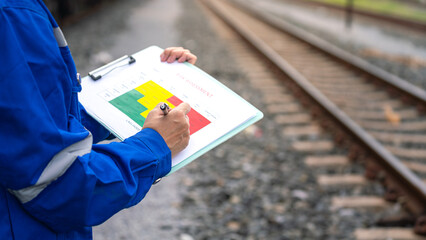 Wall Mural - a project engineer is writing on risk assessment matrix with different color that represent as risk 