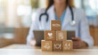 © Parradee - Wooden blocks, non-communicable disease (NCDs) icons, medication, healthy lifestyl  medical support, stacked in front of a healthcare professional with a stethoscope. Healthcare strategies for NCDs.