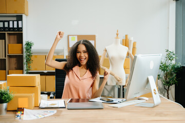 Young entrepreneur working in a creative workspace, surrounded by packaging, boxes