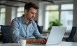 © StockLab - Photo of a young professional business man in blue shirt working at the office and looking at the screen of his laptop