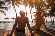 © Song_about_summer - happy couple near swimming pool, beach vacation, tropical holiday travel, silhouettes of man and woman at sunset