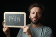 © Gio - Sad caucasian Man holding a Chalkboard with the Handwritten word  'Pain'