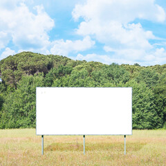 blank advertising signboard in a field with trees on background - concept with copy space and space 