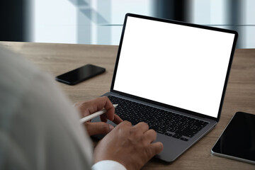 Wall Mural - man working on laptop computer with blank screen laptop computer mock up in office