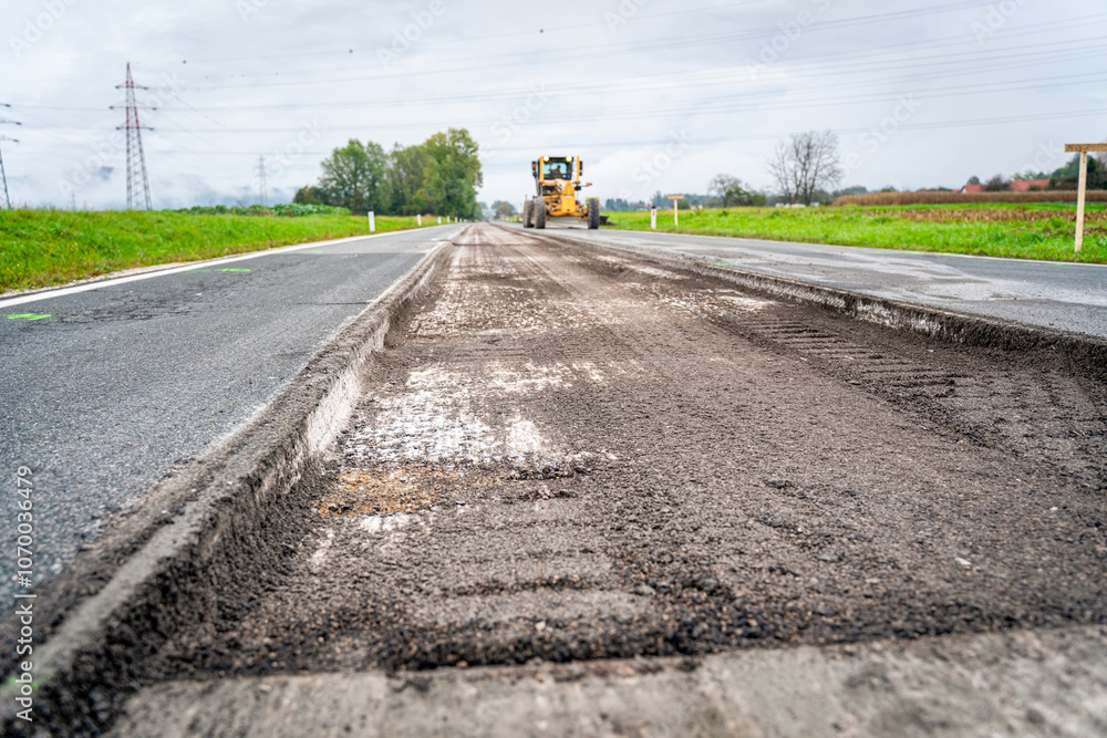 Motor grader spreading gravel at a construction site. Powerful road ...