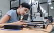 © Nassorn - Hispanic engineer woman working on AI technology in robotics electronics engineering laboratory. University students' research project is programming robot machine with intelligent mechanical control