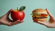 © Barosanu - On a light green backdrop, a hand holds an apple beside another hand clutching a hamburger, symbolizing the everyday choice between fast food and healthy living.