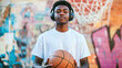 © photoholic - Teen with headphones holding basketball in urban graffiti area