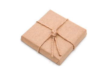 Gift box wrapped in eco craft paper with jute bow isolated on white background with copy space.	