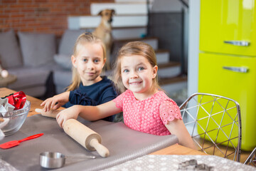 Wall Mural - Sisters rolling cookie dough making festive cookies at home