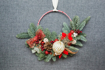 Christmas wreath with ribbon in red colors. Hand made work