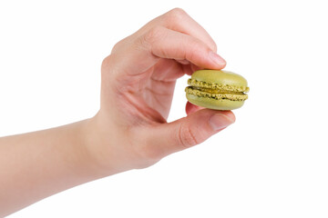 Wall Mural - young female hand holding green macaron isolated on white