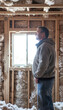 © spyrakot - Homeowner Examining Natural Fiber Insulation for Sustainable House Design