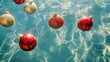 © Madeleine Steinbach - Red and golden Christmas ornaments floating in clean blue water in a pool