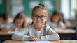 © realone952 - Little first grade girl wearing glasses smiling during a lesson at school.