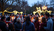 © Nadiya - Community Gathering Under String Lights Celebrating With Candles in Evening Park