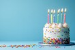 © Алена Ваторина - Colorful birthday cake with rainbow layers, white frosting, sprinkles, and seven lit candles against a vibrant blue background