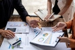 © Wasana - Business people analyzing financial documents and discussing about charts