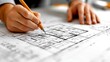 © ALIF JATI KUSUMA - Closeup of an architect's hands drawing on a blueprint.