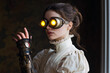 © Giada Anni - A woman in elegant attire features steampunk-style goggles and a mechanical arm, exuding a blend of Victorian and futuristic charm.