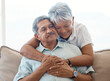 © peopleimages.com - Smile, elderly couple and hug in home for love, connection or bonding together on sofa. Senior man, happy woman or embrace for romantic commitment, marriage or relationship with partner in retirement