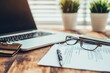 © upnowgraphics - Close-up of Documents, Glasses, and Laptop on a Wooden Table