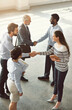 © peopleimages.com - Handshake, above and b2b with business people in office for meeting, solidarity and welcome. Collaboration, teamwork and deal with group of employees for support, thank you and shaking hands