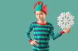 © Pixel-Shot - Cute little boy in elf costume with snowflake on green background