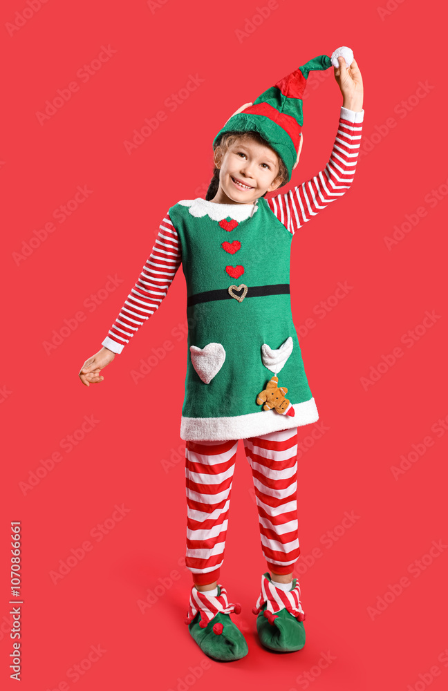 Cute little girl in elf costume on red background