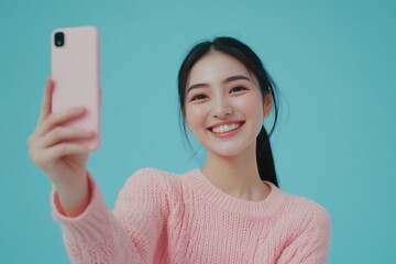 Wall Mural - A woman holding a smartphone and smiling while taking a selfie