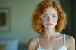 © stanhert - A woman with red hair and freckles is looking at the camera