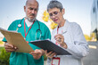 © Miljan Živković - senior man and mature woman doctor check information on clipboard