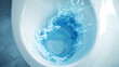© CreativeCreations - 3D illustration of a toilet bowl with blue detergent being flushed in it from above