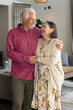© Wavebreak Media - Senior couple embracing warmly at home, celebrating Christmas together joyfully