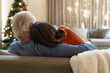 © Wavebreak Media - Senior couple relaxing on sofa, enjoying cozy Christmas at home together