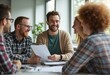 © natakot - A group of colleagues sit together in a casual office space, collaborating and discussing ideas for a project.
