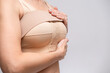 © FOTO_STOCKER - woman patient In post surgical Compression bra, implants stabilizer bra after plastic surgery medical mammoplasty, mastopexy breast enlargement, on white background