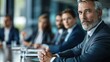 © Vilaysack - Confident senior businessman leading corporate meeting with colleagues in modern boardroom