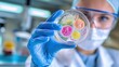 © WinThing - Scientist examining colorful microorganisms in a petri dish, laboratory setting, focused on research.