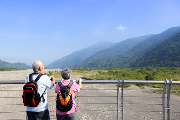 Wall Mural - Travel and tourism. Senior family couple walking together on bridge