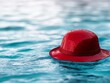 © Albert - A red hat floating in a pool of water