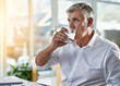 © peopleimages.com - Drinking water, office and business man at desk with executive and hydration for health. Drink, glass and mature professional at financial management company with accounting paperwork and planning