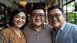 © imagineRbc - Three people smiling for a photo. The man is wearing glasses and the woman is wearing a yellow dress
