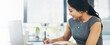 © peopleimages.com - Business woman, writing and laptop in office with notes, agenda and schedule planning at desk. Technology, professional and financial advisor with smile, paperwork and accounting document for job