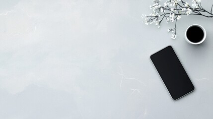 Wall Mural - A black cell phone sits on a table next to a cup of coffee