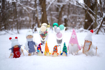 Wall Mural - Fabulous toy characters in the winter forest. Four dwarfs with glasses of champagne and Christmas angels. Next to it are two glasses with Christmas balls.