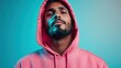 © Larisa AI - A confident man gazes at the camera, wearing a bright pink hoodie, against a gradient background, embodying modern fashion and self-assured style.