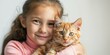 © Adobe Contributor - Little girl hugging an orange cat