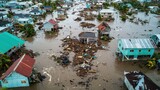 Aerial view of flooded houses surrounded by debris, showcasing the aftermath of a natural disaster and the impact of rising water levels.